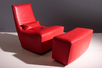 A RED LEATHER EASY CHAIR AND FOOTSTOOL, by Ligne Roset  at deVeres Auctions